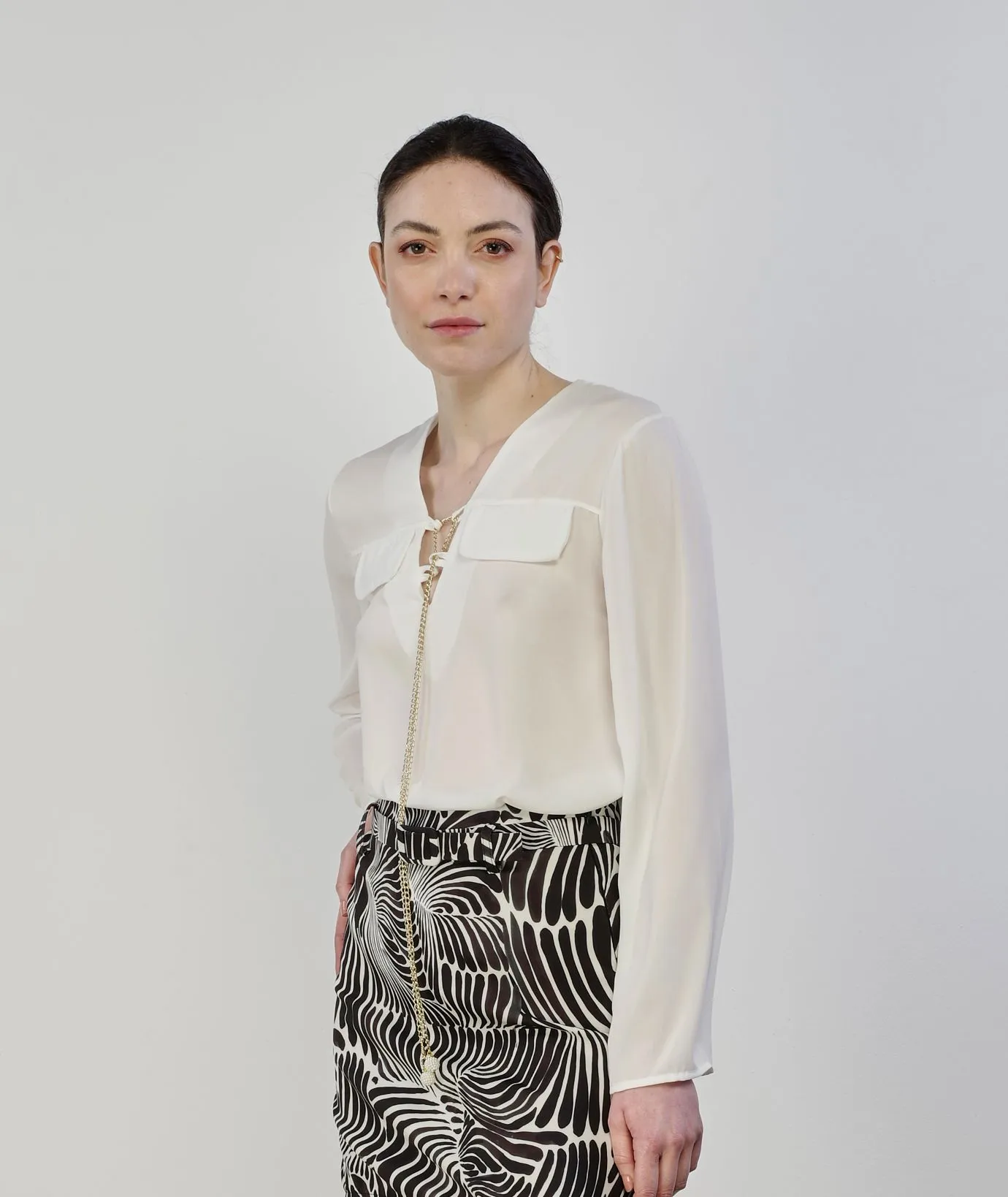 Blusa bianca con ciondolo dorato