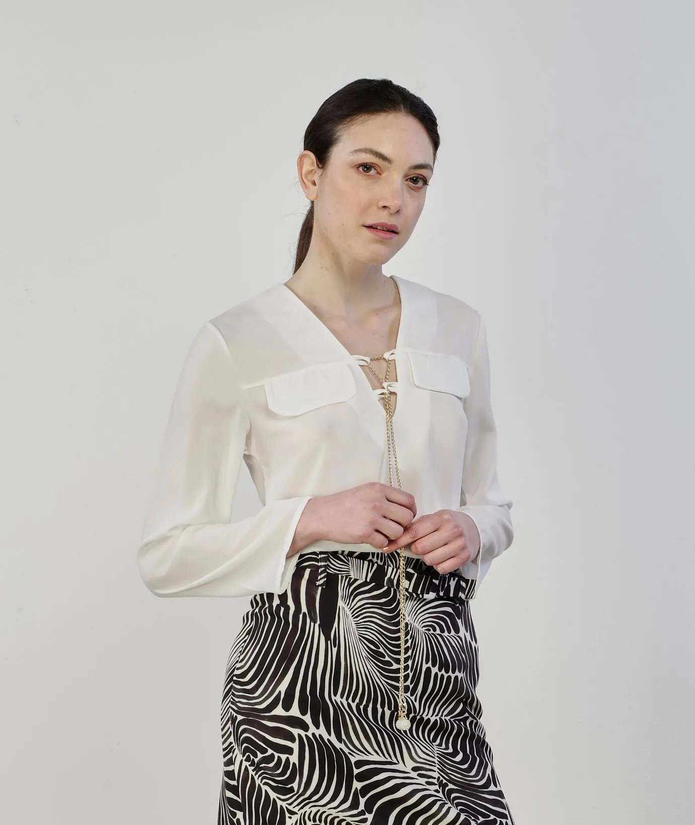 Blusa bianca con ciondolo dorato